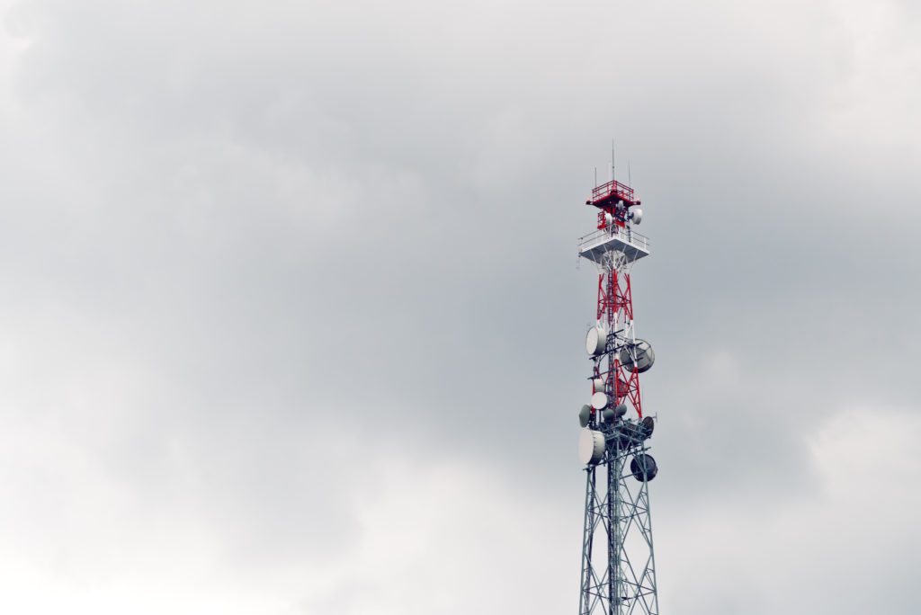 cell tower against a cloudy gray sky