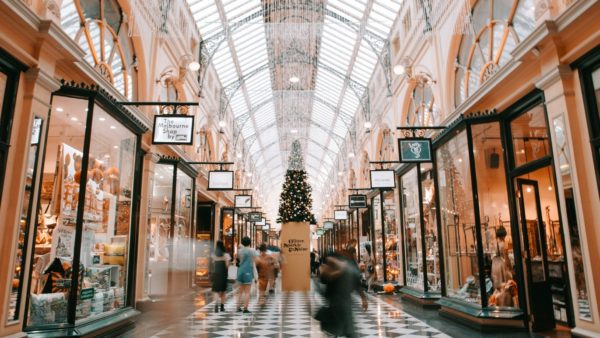 woman walking through a mall decorated for christmas