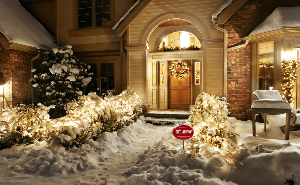 Snowy home with Christmas lights and EPS Security yard stake out front