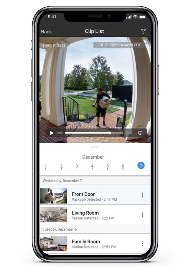 Phone with Total Connect app on the screen open, showing recorded clips, like a mail man delivering a package and many other clips below.