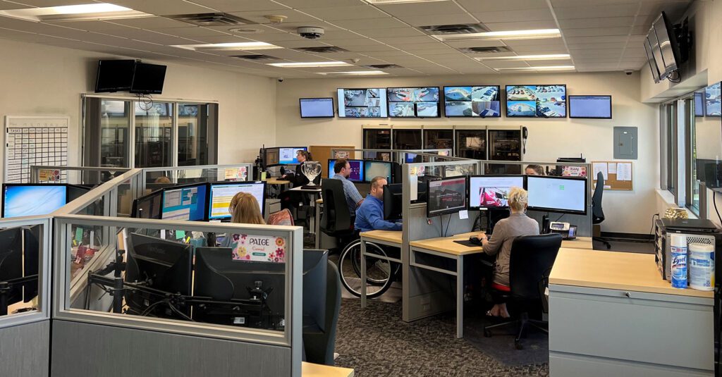 EPS Security alarm monitoring center. Operators sitting in front of computer screens and tv's surrounding with information on alerts in the area.