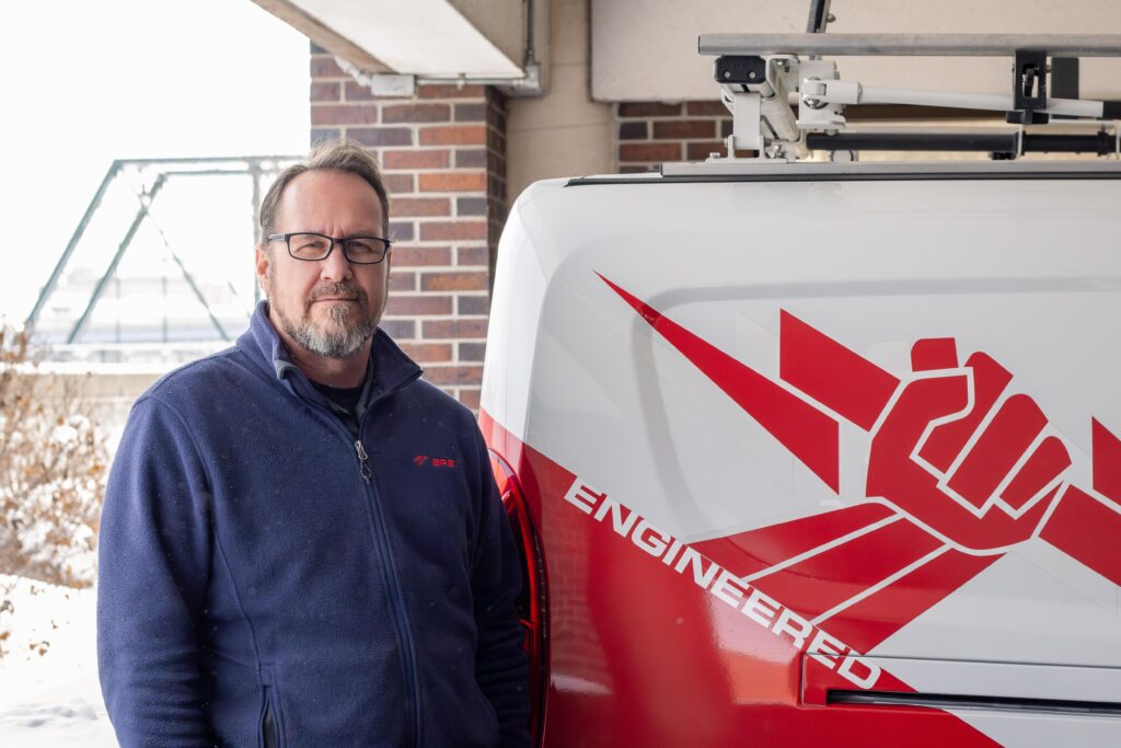 Senior technician standing next to the EPS Security truck.