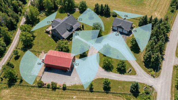 an overhead view of a large residence with multiple buildings with a security camera overlay.